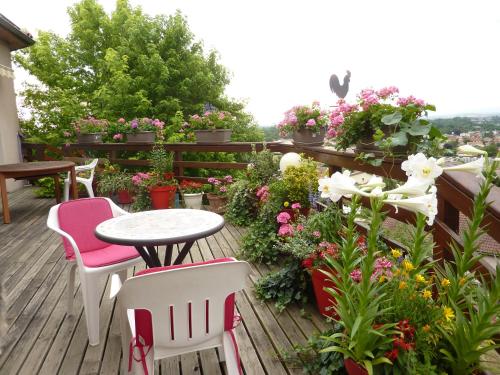 a patio with a table and chairs and flowers at Les Terrasses de Bellemoure Cébazat in Cébazat
