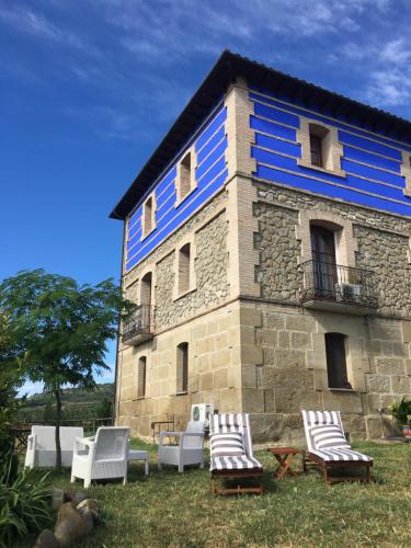a building with a group of chairs in front of it at Hotel Boutique Bodegas De Arnes - Adults Only in Graus