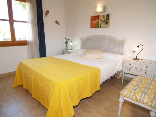 a bedroom with a bed with a yellow blanket on it at Apartment Son Durí Seawiews 15 in Sa Ràpita