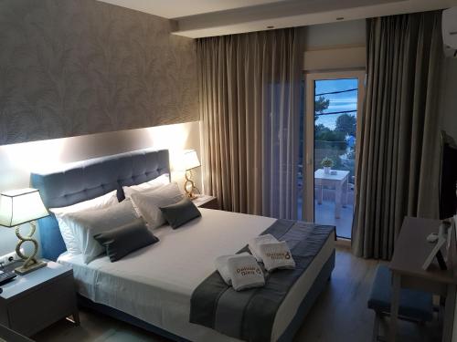 a bedroom with a large bed and a balcony at Deluxe Dina in Skala Potamias
