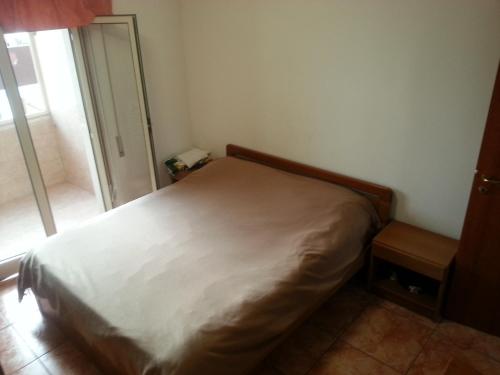 uma cama num pequeno quarto com uma janela em casa al mare a Scalea em Scalea