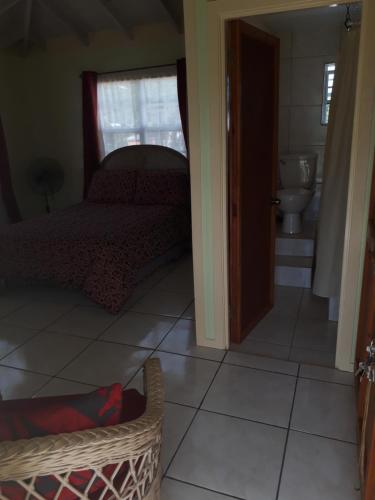 a bedroom with a bed and a bathroom with a toilet at Apartment Unforgetable Gardens in Falmouth