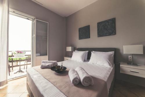a bedroom with two beds with towels on them at Teatro Deluxe Rooms in Kato Rodini