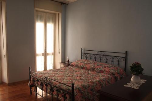 una camera da letto con un letto con un piumone e una finestra di B&B Rosa Apartment a Baveno