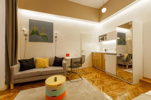 a living room with a couch and a kitchen at Tatra 4 Studios in Budapest