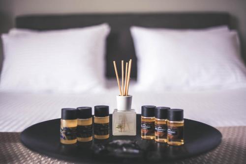 a tray with four bottles of essential oils on a bed at Teatro Deluxe Rooms in Kato Rodini