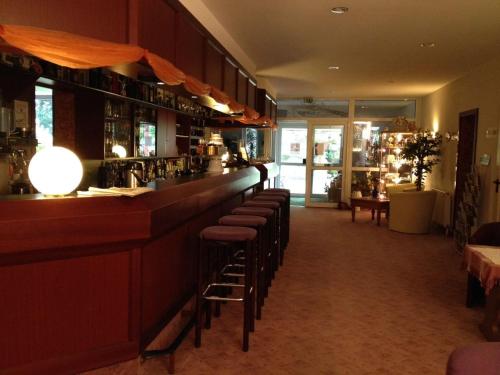 a bar with a row of stools in a restaurant at Landhotel Trampe in Trampe