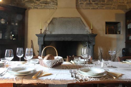 a table with plates and glasses and a fireplace at Ca' d'Alfieri in Bardi