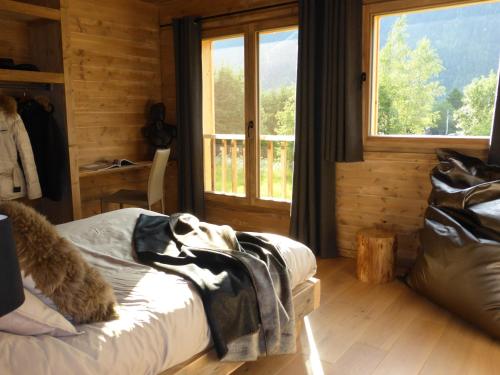 une chambre avec un lit et une grande fenêtre dans l'établissement Les Chalets Aquarelle, à Chamonix-Mont-Blanc