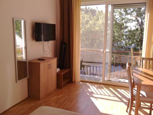 a living room with a table and a large window at Crancina in Sveti Filip i Jakov