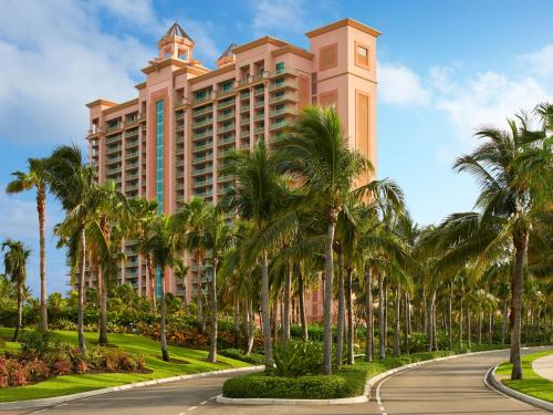 a building with palm trees in front of a road at The Cove at Atlantis in Nassau