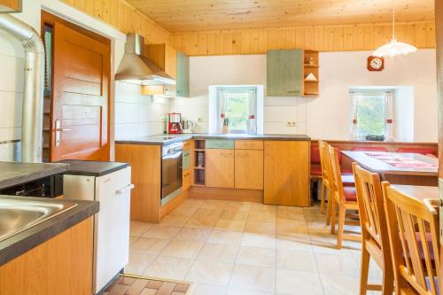 ブルック・アン・デア・グロースグロックナーシュトラーセにあるFerienhaus Unterblasbichlの木製キャビネットとテーブル付きの広いキッチンが備わります。