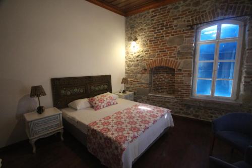 a bedroom with a bed and a brick wall at TAŞKONAK in Bergama