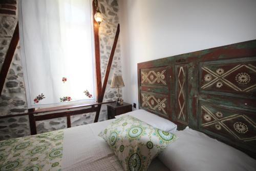 a bedroom with a bed with a wooden headboard and a pillow at TAŞKONAK in Bergama