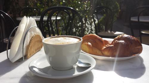 a cup of coffee and a plate of croissants on a table at Hotel Firenze 2000 in Florence