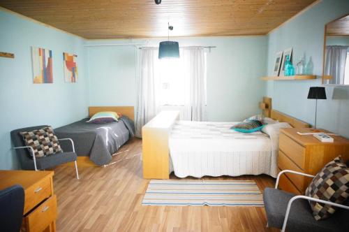 a small bedroom with two beds and a couch at Åker Kristinagården in Skillingaryd