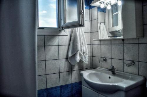 a small bathroom with a sink and a mirror at Mainades Maisonettes & Studios in Ménites