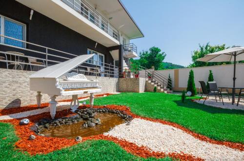 a house with a garden with a piano in the yard at Pensiunea Avy in Haţeg