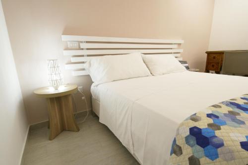 sypialnia z dużym białym łóżkiem i stołem w obiekcie Casa Dante Bed&Breakfast w mieście Mattinata