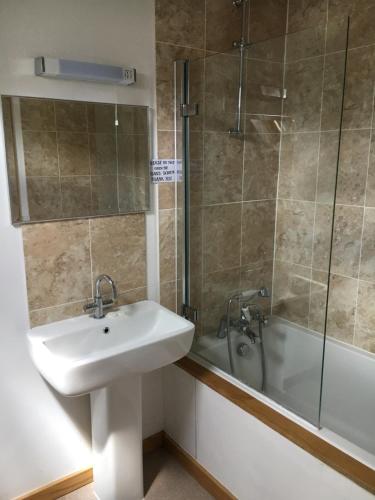 a bathroom with a sink and a shower and a tub at The Lampet Arms in Banbury