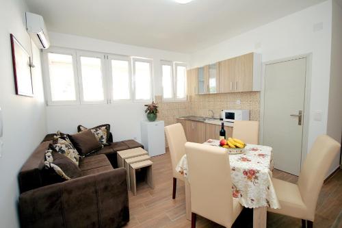 a living room and kitchen with a couch and a table at Apartments Centar Sutomore in Sutomore
