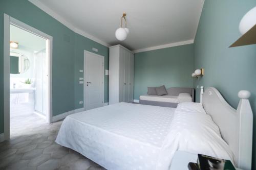 a bedroom with a white bed and a blue wall at AleMar Sirolo in Sirolo