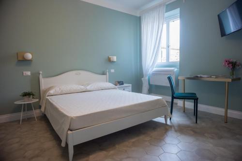 a bedroom with a bed and a chair and a window at AleMar Sirolo in Sirolo