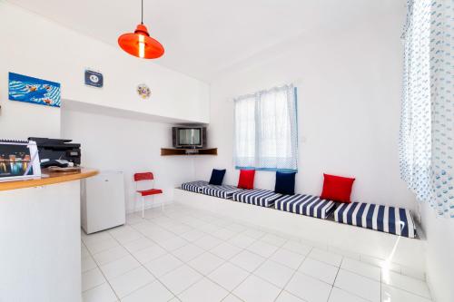 a room with a long bench with red and blue pillows at Fivos Apartments in Aliki