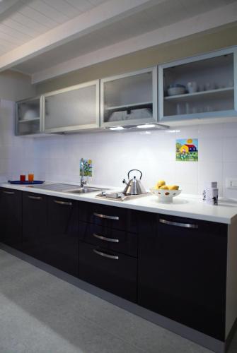 a kitchen with black cabinets and a sink at Palazzo Ossuna in Trapani