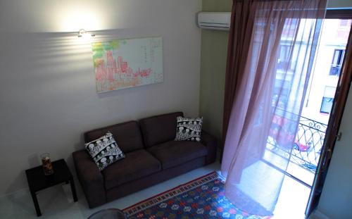 a living room with a couch and a window at Palazzo Ossuna in Trapani