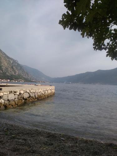 a beach with a retaining wall next to the water at Apartments Nadja in Kotor
