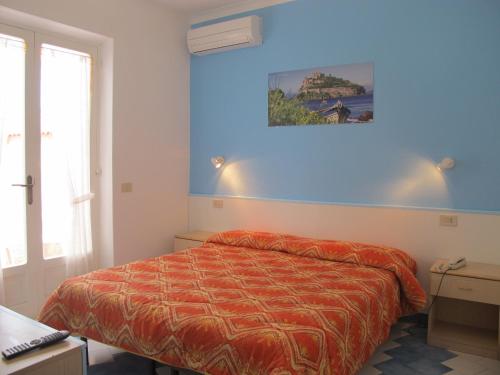 a bedroom with a bed and a blue wall at Aparthotel Villa Marinù in Ischia