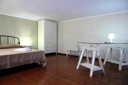 a bedroom with a bed and a table and stool at Palazzo Ossuna in Trapani