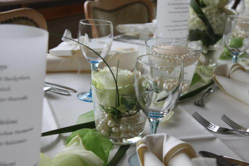 a table with glasses and flowers in a vase at Natur & Wander Hotel Gassbachtal in Grasellenbach