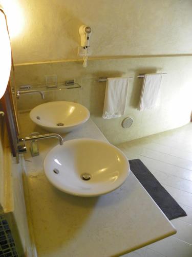 a bathroom with two sinks and towels on a counter at Locus Amoenus in Matera