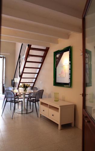 a living room with a table and chairs and a staircase at Palazzo Ossuna in Trapani