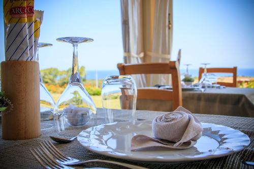 a table with a plate with a napkin on it at Abbaidda Hotel in Valledoria