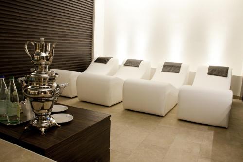 a room with white couches and a trophy on a table at Hotel Queen Mary in Cattolica