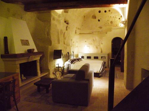 a bedroom with a bed and a couch and a fireplace at Locus Amoenus in Matera