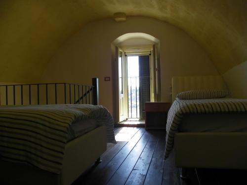 an attic room with two beds and a window at Locus Amoenus in Matera