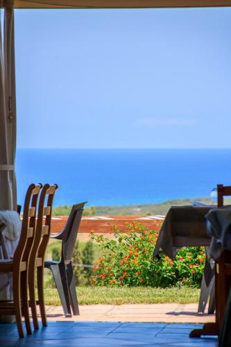 a couple of chairs sitting on a porch with a view of the ocean at Abbaidda Hotel in Valledoria