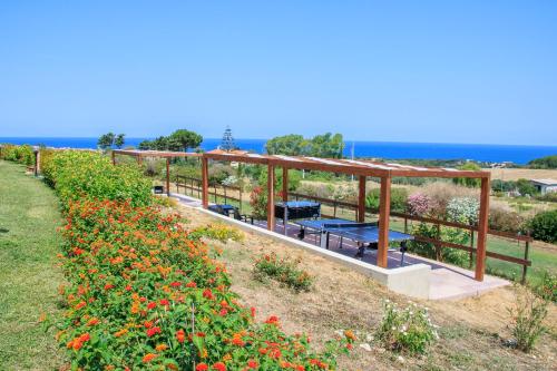 a garden with benches and flowers in a field at Abbaidda Hotel in Valledoria