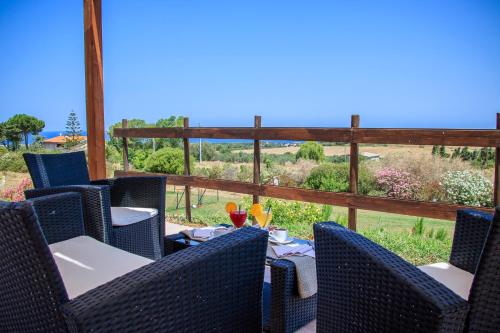 a patio with chairs and tables and a view of the ocean at Abbaidda Hotel in Valledoria