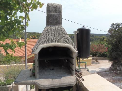 un four à pizza extérieur installé dans une cour dans l'établissement Apartments Branko, à Veli Rat
