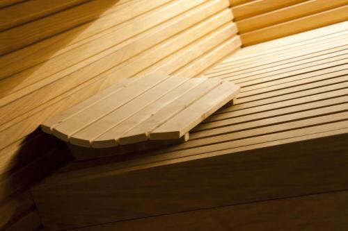 a wooden bench sitting on top of a wooden floor at Hotel Queen Mary in Cattolica