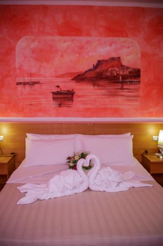 a bed with two swans on it with a painting at Abbaidda Hotel in Valledoria