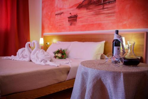a bedroom with a bed with a bottle of wine on a table at Abbaidda Hotel in Valledoria
