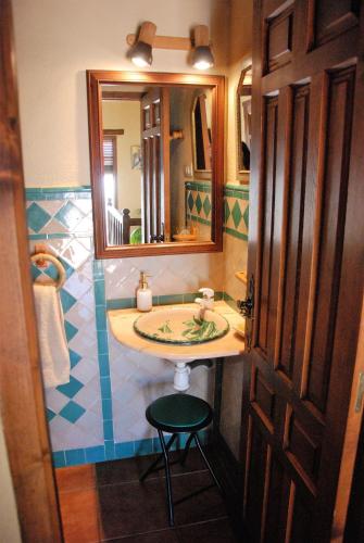 a bathroom with a sink and a mirror and a stool at Casa Africa in Mecina Fondales