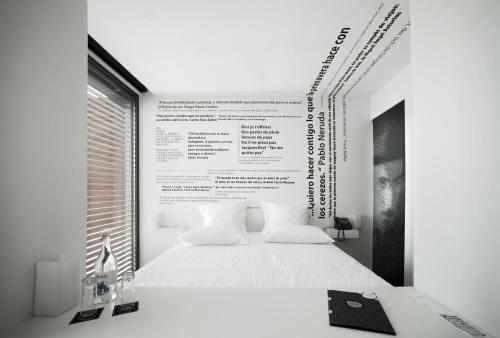 a bedroom with a white bed with a large poster on the wall at Design & Wine Hotel in Caminha
