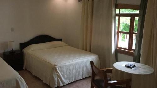 a bedroom with a bed and a table and a window at Hotel y Restaurante Costa del Sol in Mata de Limón
